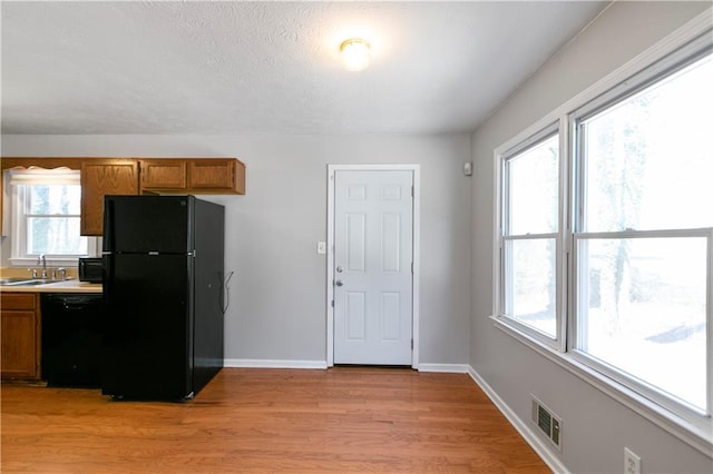37 Indian Hills Ct, Dallas, GA 30157 - kitchen featuring light wood finished floors, baseboards, visible vents, brown cabinets, and black appliances