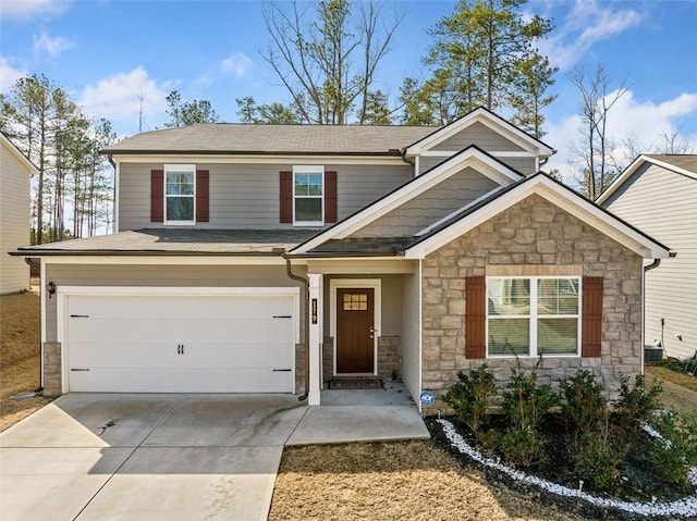 view of front of house with stone siding, cooling unit, concrete driveway, a shingled roof, and a garage