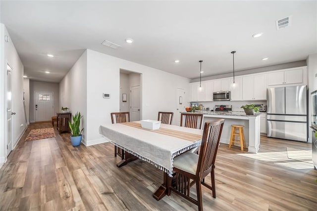 dining area with visible vents, recessed lighting, light wood-type flooring, and baseboards