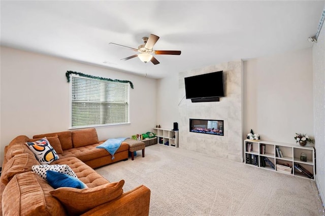 living area featuring a ceiling fan, carpet, and a fireplace