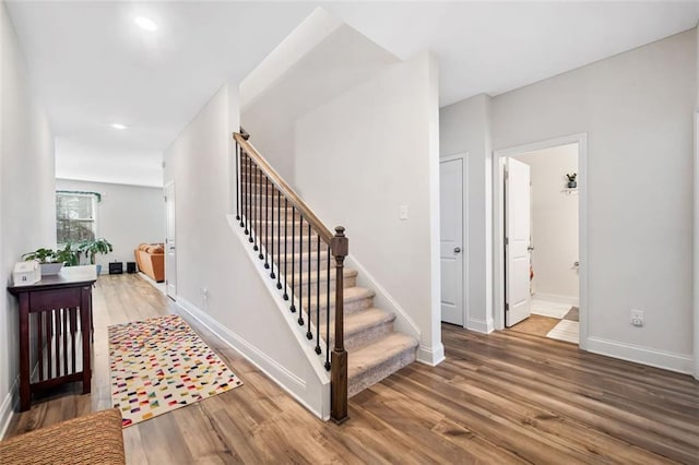 stairway featuring recessed lighting, baseboards, and wood finished floors