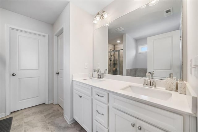 bathroom featuring double vanity, visible vents, a stall shower, and a sink