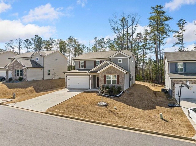 traditional-style home with stone siding, concrete driveway, and a garage