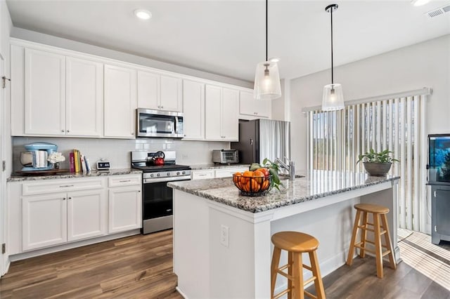 kitchen with dark wood finished floors, white cabinets, visible vents, and appliances with stainless steel finishes