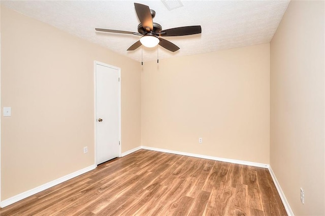 empty room featuring light wood-style floors, ceiling fan, baseboards, and a textured ceiling