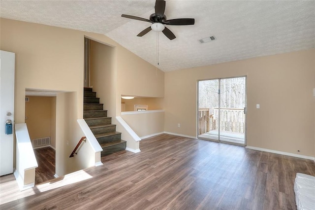 unfurnished living room featuring vaulted ceiling, a textured ceiling, wood finished floors, and baseboards