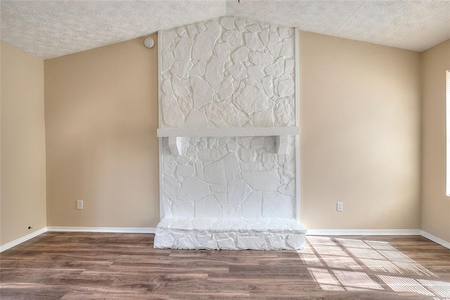 interior space with a textured ceiling, wood finished floors, and baseboards