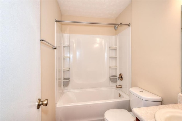 bathroom with toilet, washtub / shower combination, a textured ceiling, and vanity