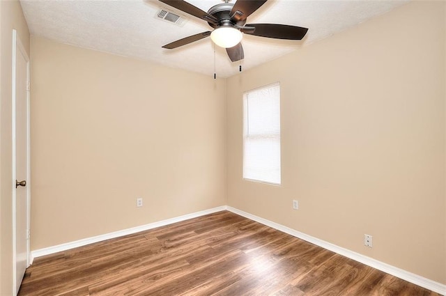 spare room with baseboards, a textured ceiling, visible vents, and wood finished floors