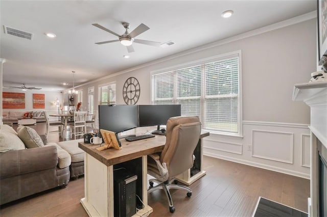 office space featuring visible vents, a ceiling fan, wainscoting, and ornamental molding