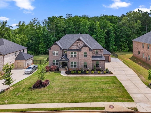 craftsman-style house featuring a garage, a front yard, brick siding, concrete driveway, and a view of trees