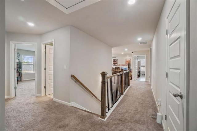 hallway with light carpet, recessed lighting, baseboards, an upstairs landing, and visible vents