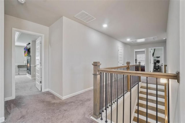 corridor featuring carpet, recessed lighting, baseboards, an upstairs landing, and visible vents