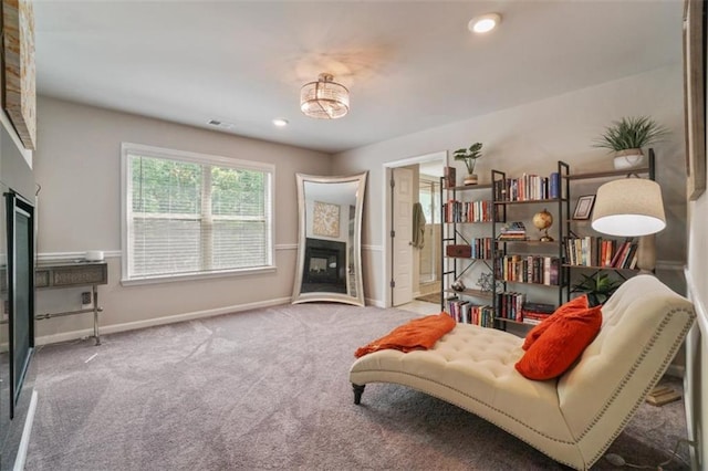 living area featuring a glass covered fireplace, baseboards, carpet, and recessed lighting