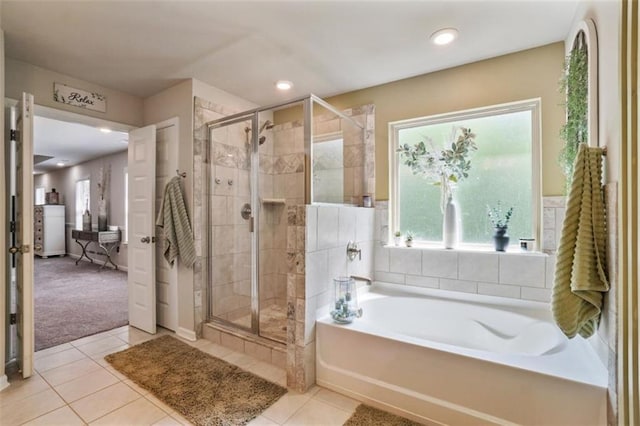 full bath with tile patterned floors, a bath, and a stall shower