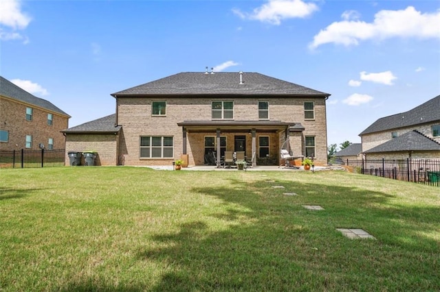 rear view of property with brick siding, a patio area, and a yard