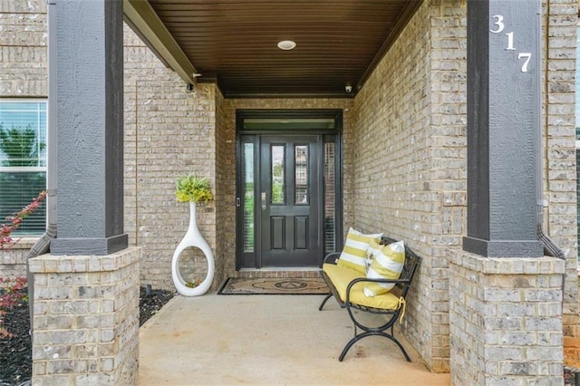 doorway to property featuring brick siding