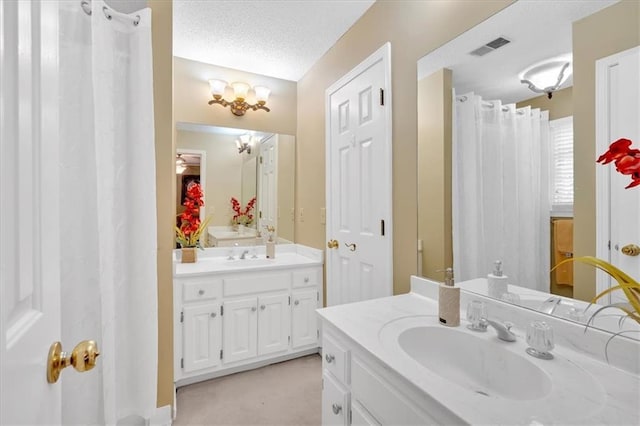 5891 Ranger Ct, Peachtree Corners, GA 30092 - bathroom featuring two vanities, a textured ceiling, and a chandelier