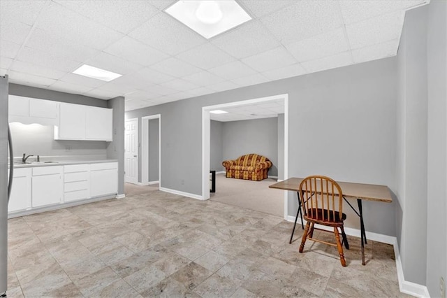 5891 Ranger Ct, Peachtree Corners, GA 30092 - kitchen featuring a paneled ceiling, light countertops, white cabinets, a sink, and baseboards