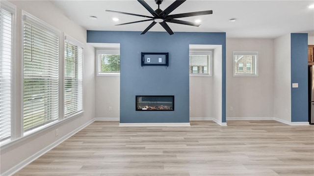 1570 Halbrook Pl, Marietta, GA 30008 - unfurnished living room with light wood finished floors, baseboards, ceiling fan, a glass covered fireplace, and recessed lighting