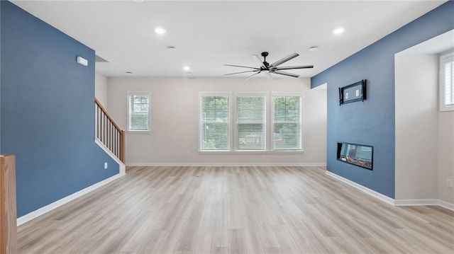 1570 Halbrook Pl, Marietta, GA 30008 - unfurnished living room with a ceiling fan, light wood finished floors, a glass covered fireplace, and recessed lighting