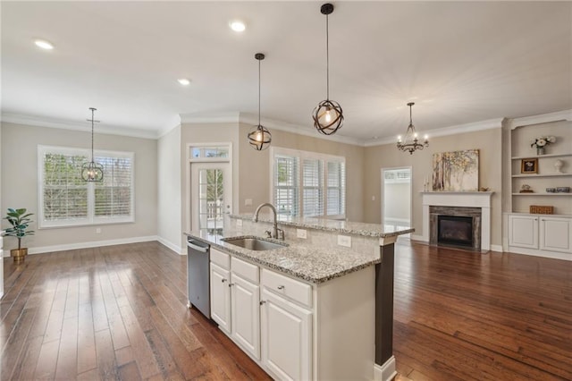 kitchen featuring dishwasher, white cabinetry, sink, hanging light fixtures, and a kitchen island with sink