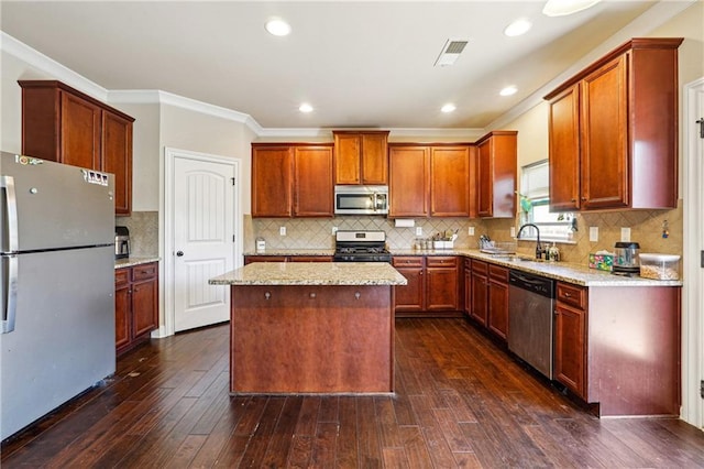 kitchen with a center island, visible vents, appliances with stainless steel finishes, dark wood-type flooring, and a sink