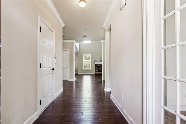 corridor with baseboards, dark wood-type flooring, and crown molding