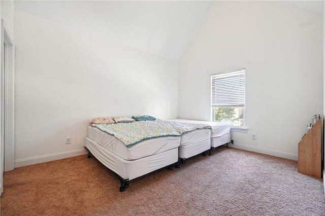 bedroom with high vaulted ceiling, carpet flooring, and baseboards