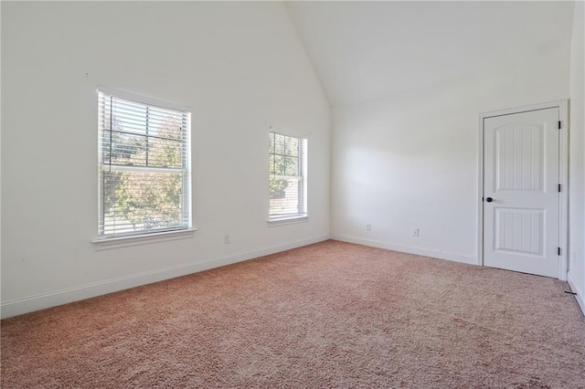 unfurnished room featuring carpet floors, baseboards, and high vaulted ceiling