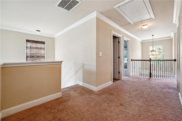 hall featuring carpet floors, attic access, visible vents, and ornamental molding