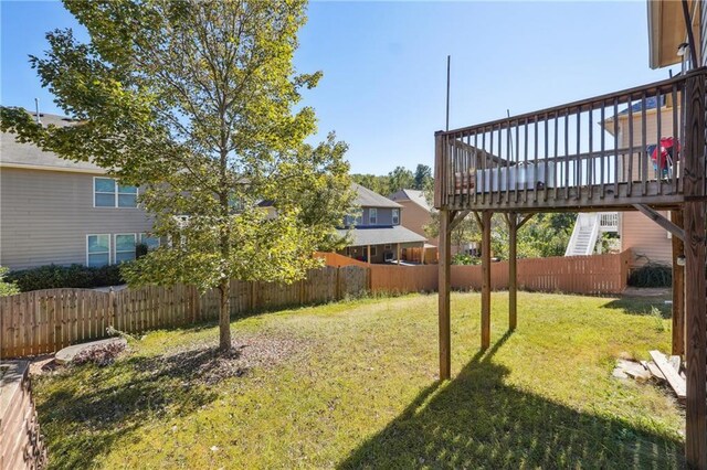 view of yard with fence private yard, stairway, and a wooden deck