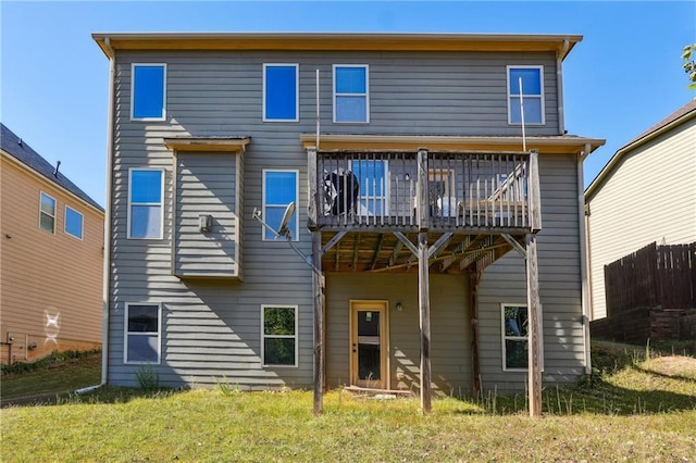 rear view of house with a deck and a yard