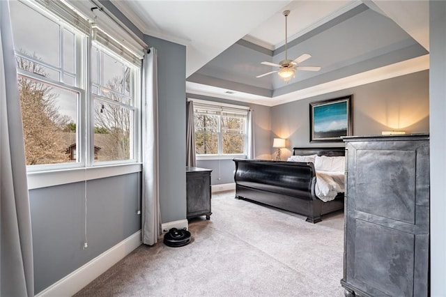 carpeted bedroom featuring a raised ceiling, ceiling fan, and ornamental molding