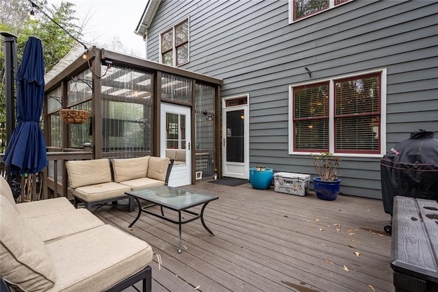 wooden deck with an outdoor hangout area and grilling area