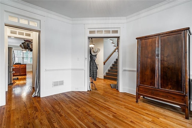 entrance foyer featuring crown molding and light wood-type flooring