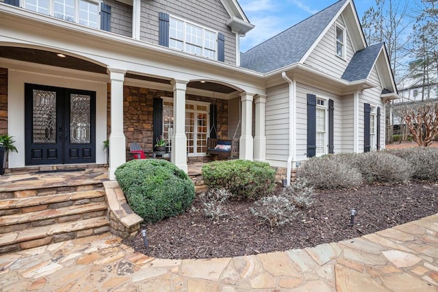 entrance to property featuring covered porch and french doors