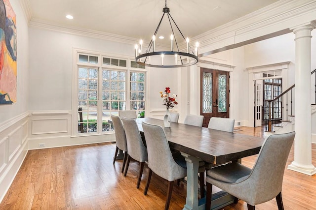 dining area with french doors, crown molding, light hardwood / wood-style floors, and ornate columns