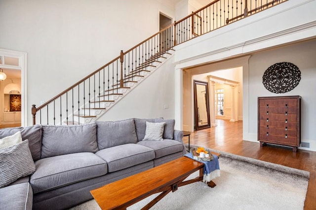 living room featuring dark wood-type flooring and a high ceiling