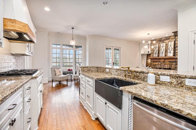 kitchen with custom exhaust hood, appliances with stainless steel finishes, pendant lighting, and white cabinets