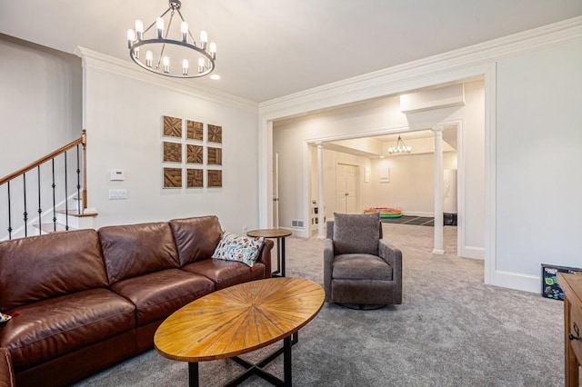 carpeted living room featuring ornamental molding, a chandelier, and ornate columns