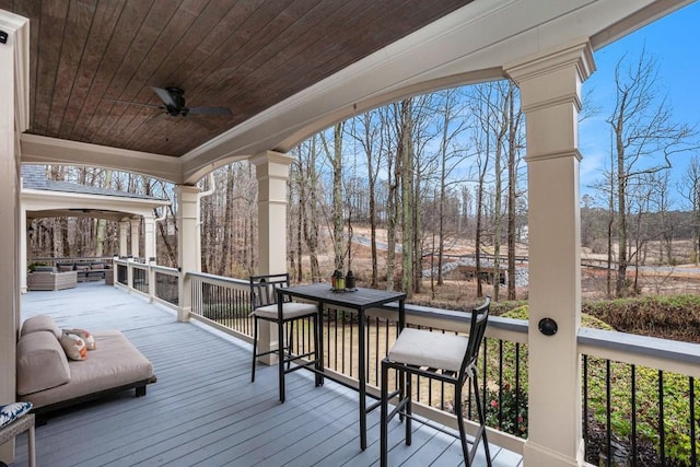 wooden terrace with outdoor lounge area and ceiling fan