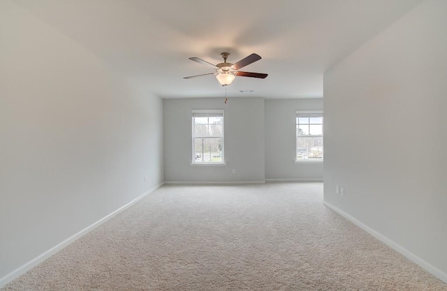 spare room featuring light colored carpet and ceiling fan