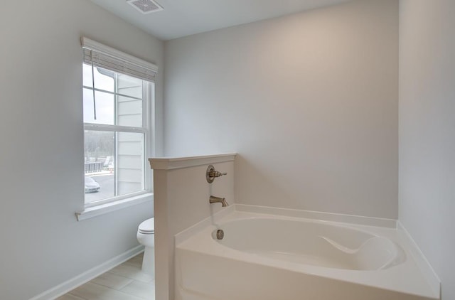 bathroom featuring a tub and toilet