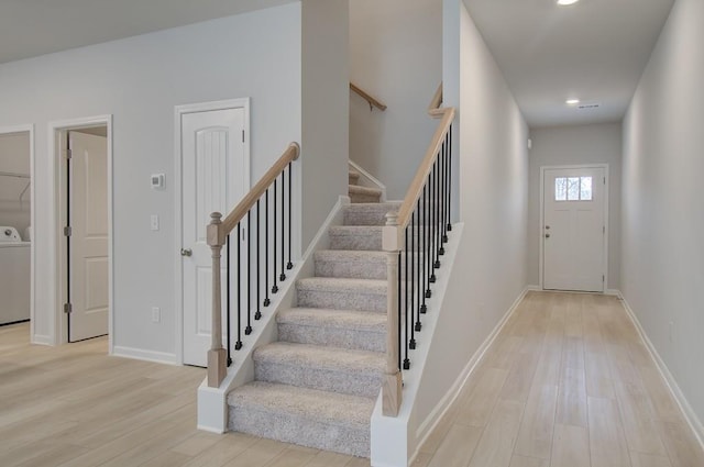 entrance foyer with washer / clothes dryer and light hardwood / wood-style floors