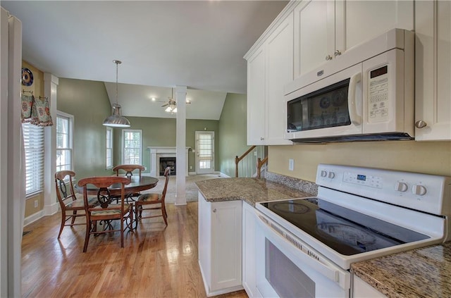 27 Planters Dr NW, Cartersville, GA 30120 - kitchen with white appliances, white cabinets, light wood-style flooring, a premium fireplace, and open floor plan
