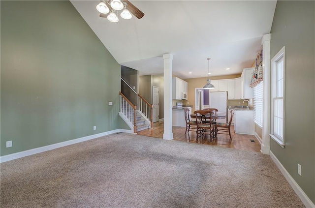 27 Planters Dr NW, Cartersville, GA 30120 - dining space featuring light colored carpet, ceiling fan, stairs, baseboards, and vaulted ceiling