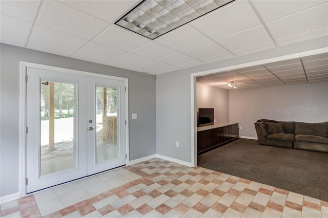doorway featuring french doors, a paneled ceiling, baseboards, light tile patterned floors, and light carpet