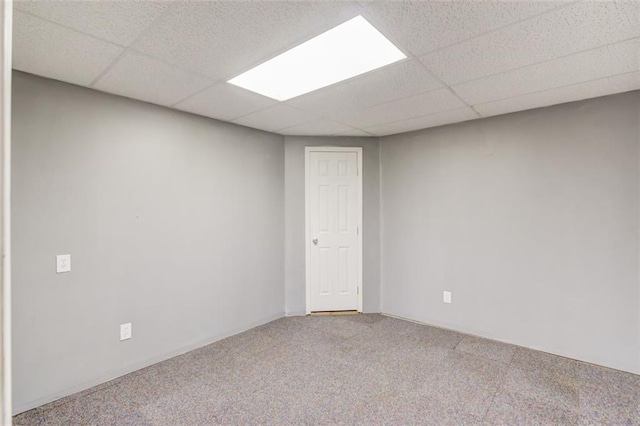 spare room featuring carpet floors and a paneled ceiling
