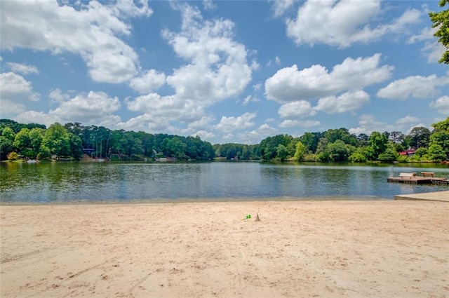 water view featuring a floating dock and a heavily wooded area